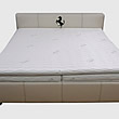 Čalouněná postel na míru s výšivkou koně. Potah postele z bílé kůže je ozdoben dvojitým prošíváním černou nití. Pro dokonalý komfort jsou jednotlivé matrace překryty 6cm deskou z líné pěny.