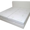 Bílá postel s úložným prostorem. Tuto postel jsme očalounili bílou koženkou. Úložné prostory jsou z bílého lamina, rošty jsou pevné smrkové. Dvě matrace o rozměrech 18x100x200 cm jsou středně tvrdé a jsou ze studené a líné pěny. Postel stojí na nízkých plastových kluzácích. Korpus postele má, kvůli úspoře prostoru, stejné rozměry, jako mají matrace (200x200 cm). Čelo je tenké (6 cm) a je vysoké 100 cm. Lehací plocha je ve výšce 40 cm.
