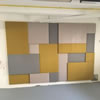 Realizace ČVUT Praha, akustické panely na stěně u tabule vpravo. Na čalounění panelů jsme použili látku Bombay v šedém, béžovém a žlutém odstínu.