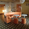 Oranžové kruhové lavice s taburety ve tvaru válce. 
