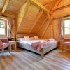 Křesla Kolombo, přehoz přes postel a závěsy z potahové textilie Walchensee. Dřevěná postel s luxusní matrací Magniflex.