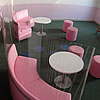 Růžové koženkové lavice s malými taburetky.
